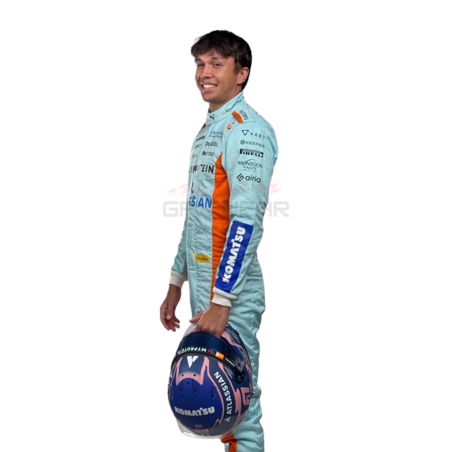 Alexander Albon wearing a light blue 2025 Williams Sao Paul GP F1 racing suit with various sponsor logos, holding a helmet - GPX WEAR