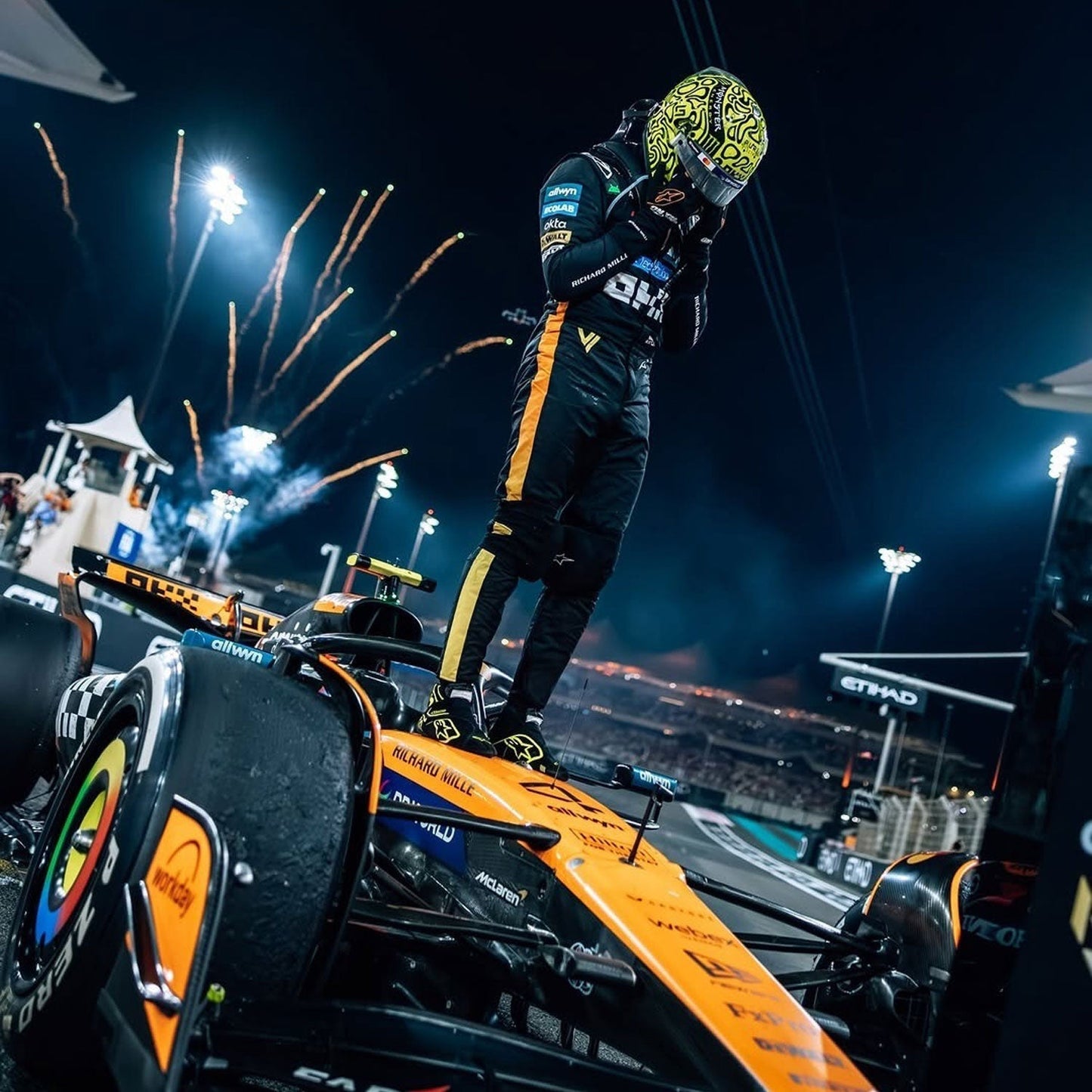 Lando celebrating on a Formula 1 car with fireworks in the background