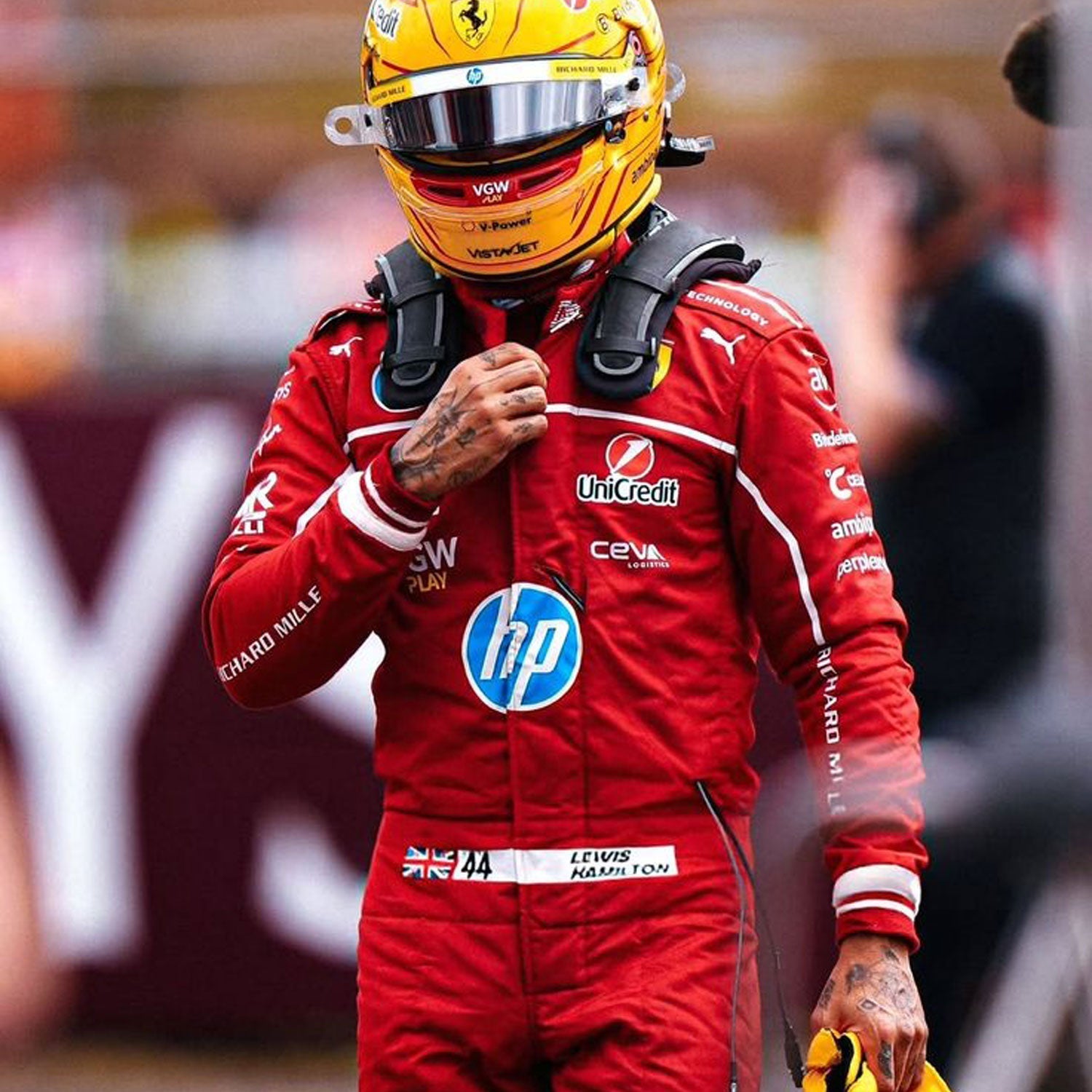 Formula 1 driver Lewis Hamilton in red 2025 Ferrari F1 racing suit with helmet and visible branding - GPX WEAR