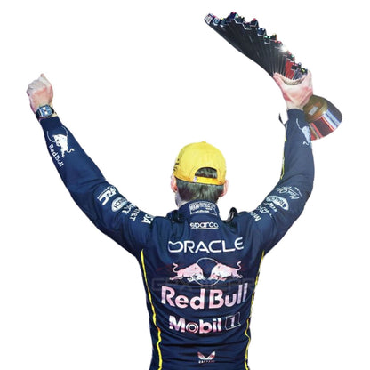 Max Verstappen wearing a black 2025 Red Bull Las Vegas GP F1 racing suit with visible branding holding a trophy against - GPX WEAR