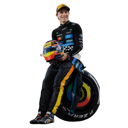 2025 Oscar Piastri Abu Dhabi GP F1 Racing Suit  holding a helmet next to a racing tire on a white background