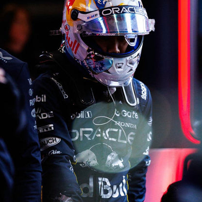 Yuki Tsunoda wearing a black 2025 Red Bull Las Vegas GP F1 racing suit and helmet with Oracle and Honda branding in a dark setting - GPX WEAR