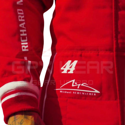 Close-up of a red racing suit with white text and logos, including 'RICHARD M', the number '44', and 'Michael Schumacher'.